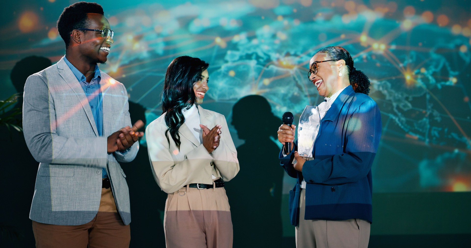 People, stage and happy at conference with applause for achievement, success and congratulations. Diversity, teamwork and support at seminar or award ceremony event and summit for global networking
